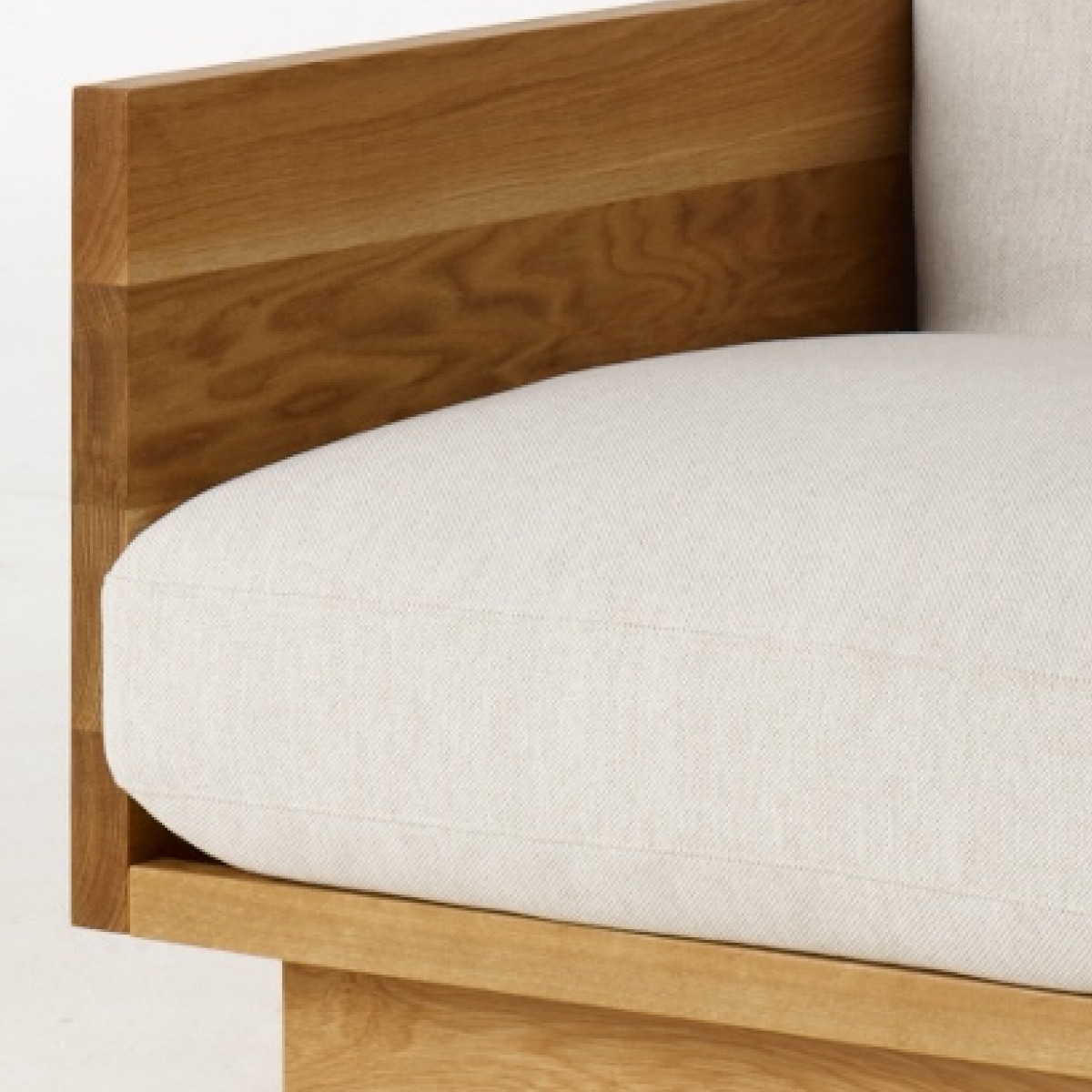 A detail view of the Pawson Drift Sofa Groups front corned with solid wood oak and grey cushion.