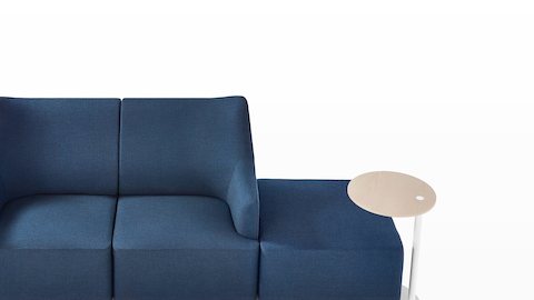 Vista superior de perto de um assento Plex que inclui um sofá Loveseat adjacente a uma otomana azul e mesa de trabalho.