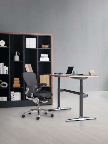 Port Storage System with a wooden frame and black shelves behind an Atlas height-adjustable desk with an Aeron Chair.