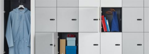 Port Storage System with small white and gray lockers and double hinge doors against a wall.