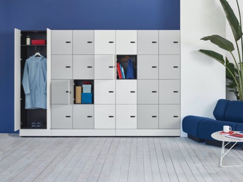 Port Storage System with small white and gray lockers and double hinge doors against a wall. Port Storage System with small white and gray lockers and double hinge doors against a wall.
