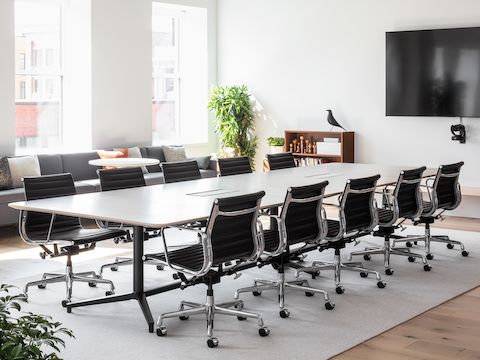 A large, well-lit conference room with a Headway Table and ten black Eames Aluminum Group Chairs.