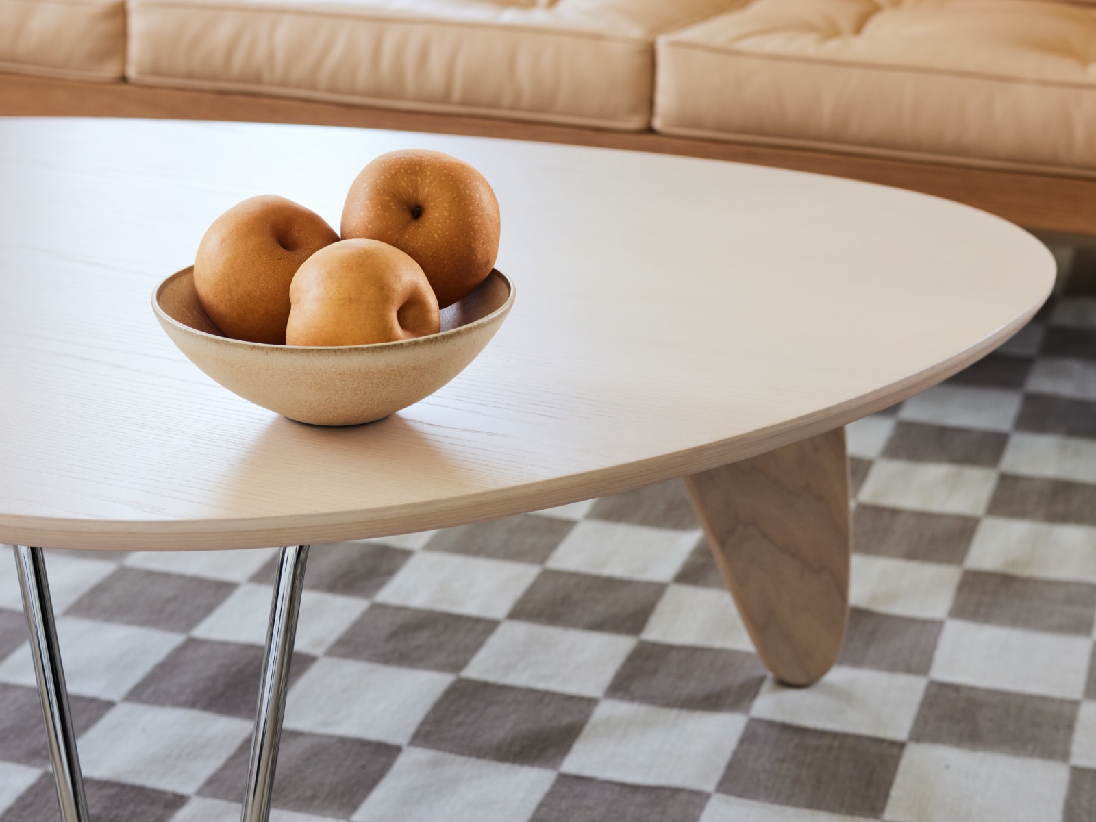 A close-up view of the Noguchi Rudder Table on a Girard Check Rug.