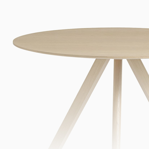 A round HAY Copenhague Table with three legs in oak. Select to view all HAY tables.