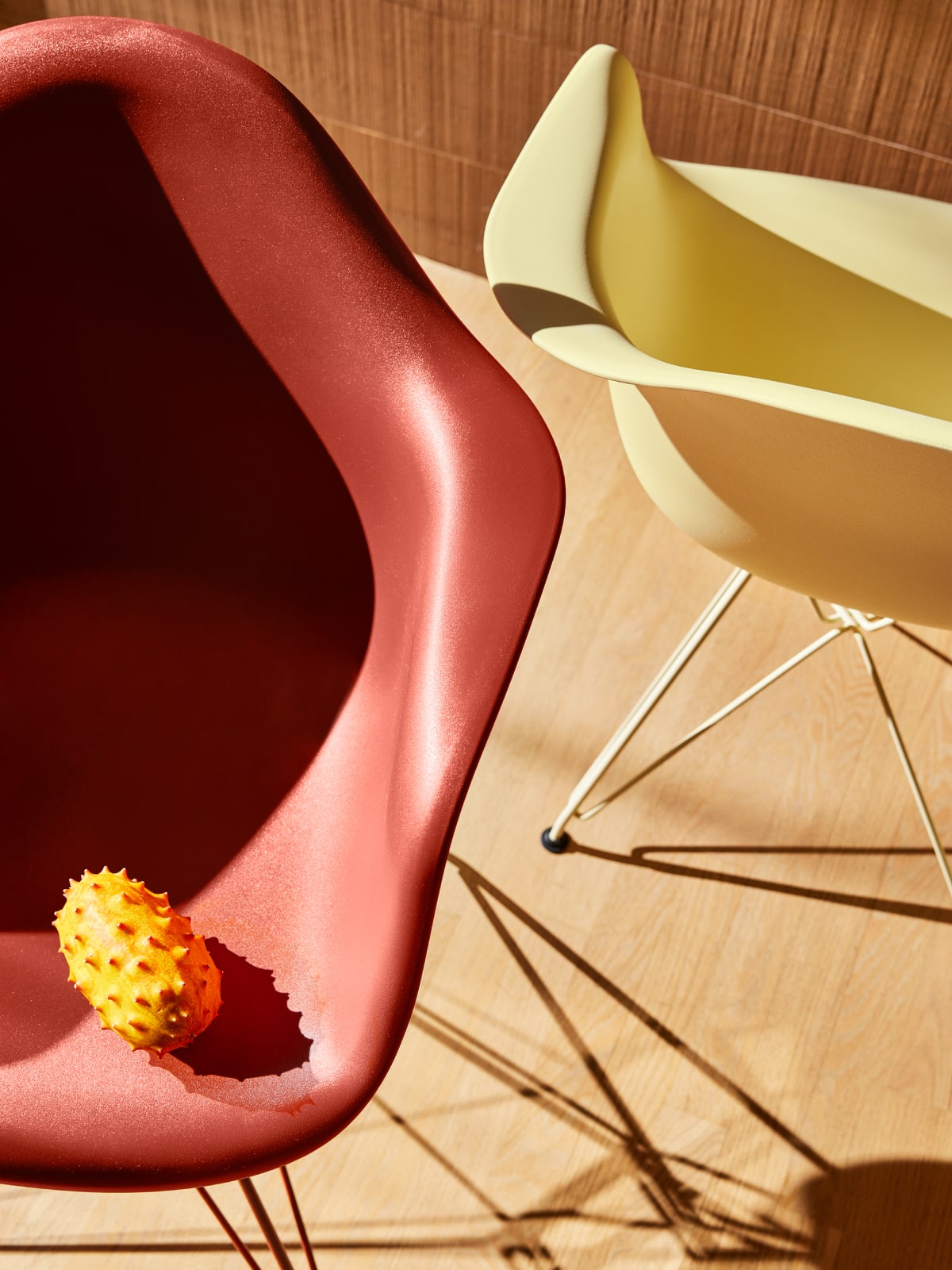 Herman Miller x HAY, Eames Molded Plastic Armchair details of iron red and yellow, with fruit