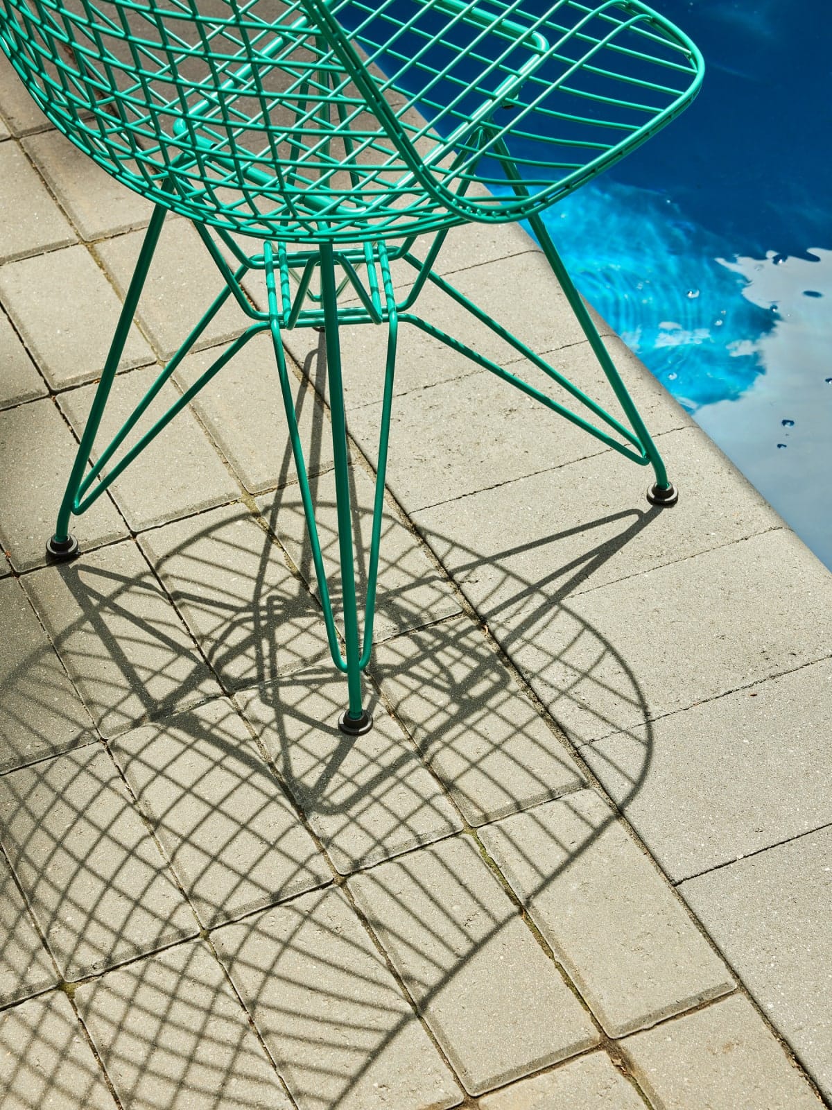 Ambiente exterior con silla Eames Wire de Herman Miller x HAY en color verde.