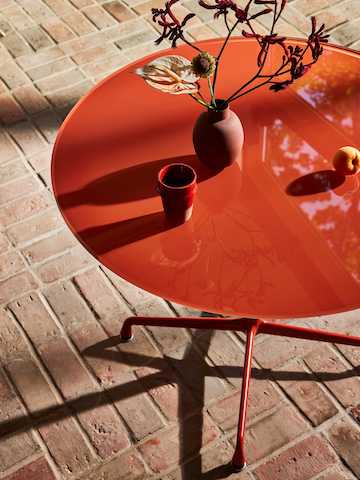 Herman Miller x HAY Eames Universal Base Round Table in iron red.