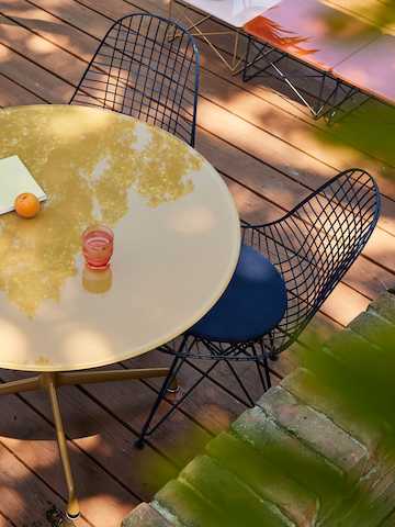 Ambiente exterior con mesa Eames y silla Eames Wire de Herman Miller x HAY.