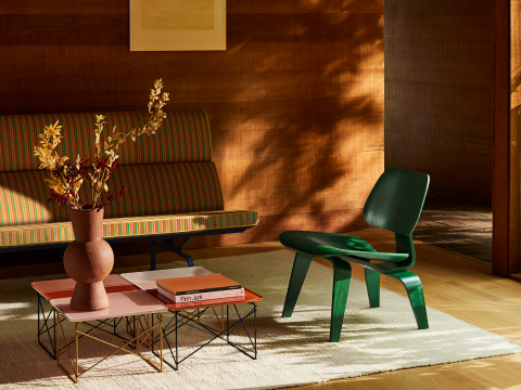 Ambiente de sala de estar de Herman Miller x HAY con sofá Eames Compact, silla de madera laminada moldeada y mesas Eames con base de alambre.