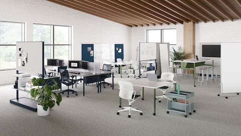 Produtos da Coleção para espaços de trabalho OE1 em uma configuração em plano aberto, incluindo mesas, paredes móveis, tela de monitor e trilho e painéis de parede.