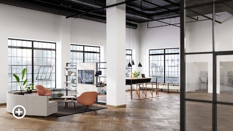 An open floor workplace with soft seating, a communal table and phone booths.