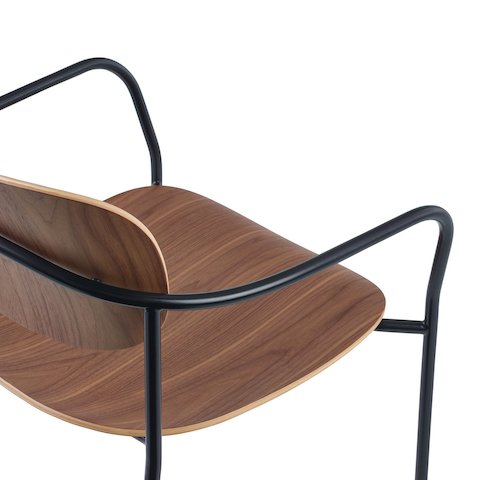 Portrait座椅的细节图：搭配胡桃木椅座和靠背、黑色框架，带扶手。