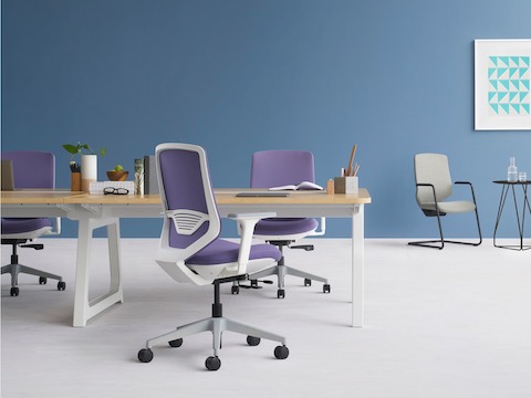 Three POSH Express 2 Chairs with Optimis Bench Table in a workstation setting. Two POSH Express 2 side chairs with mini table in the background in a casual meeting setting.