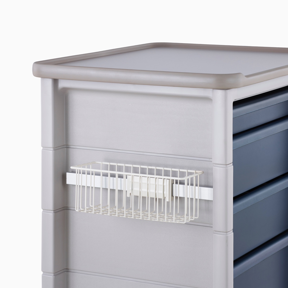 Detail of Procedure and Supply Cart in a light gray body and dark blue drawers and a supply basket hung on the side of the cart's adapter rail.