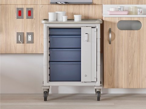 Locked supply cart with blue drawers in a patient room with a Compass System headwall.