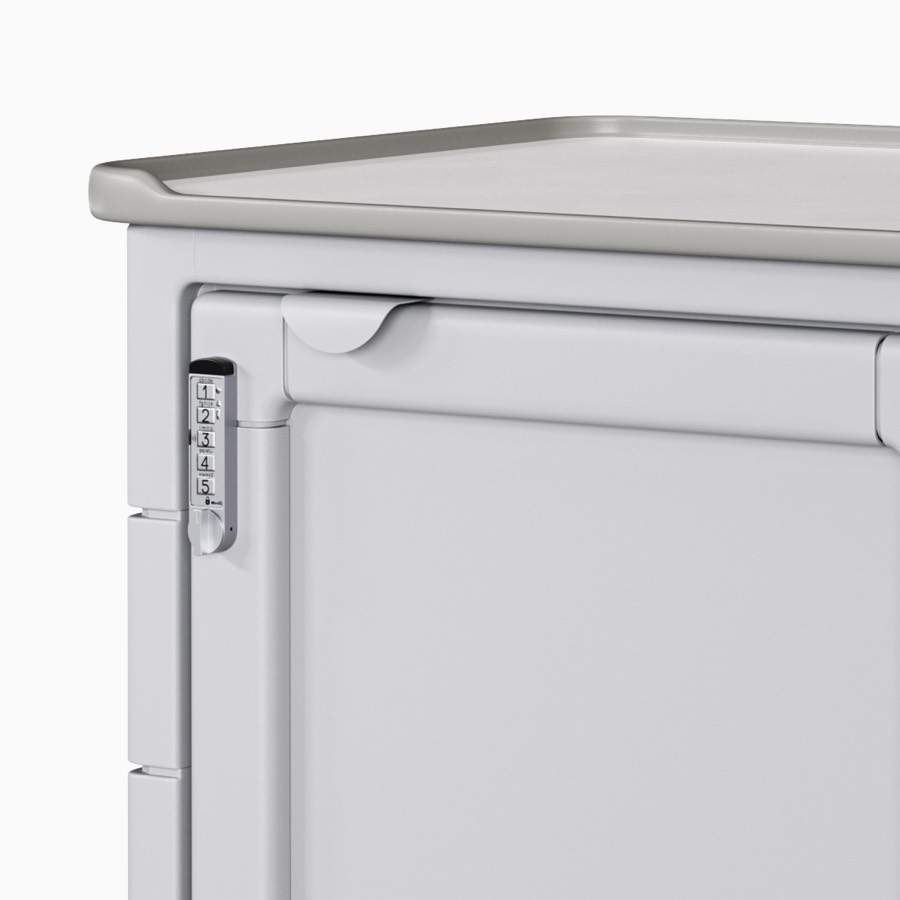 Detail of a procedure and supply cart in a light gray body with a fully enclosed door and a keyless lock.
