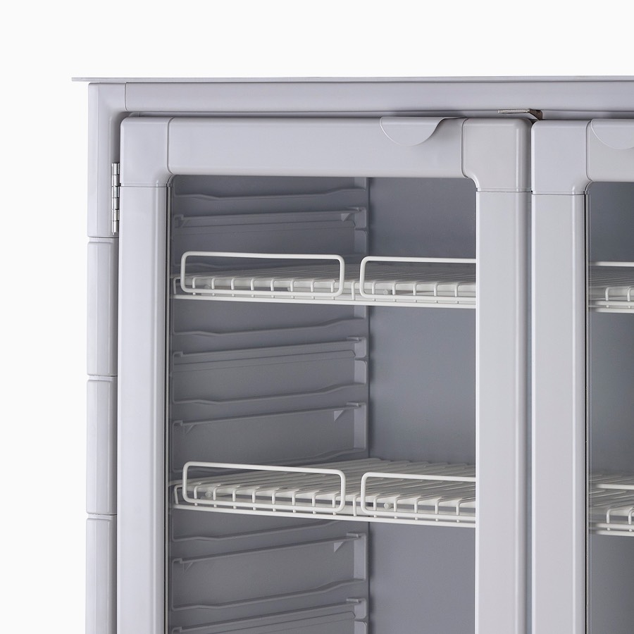 Glass door and wire shelf detail of double-wide procedure and supply cart in a light gray finish.