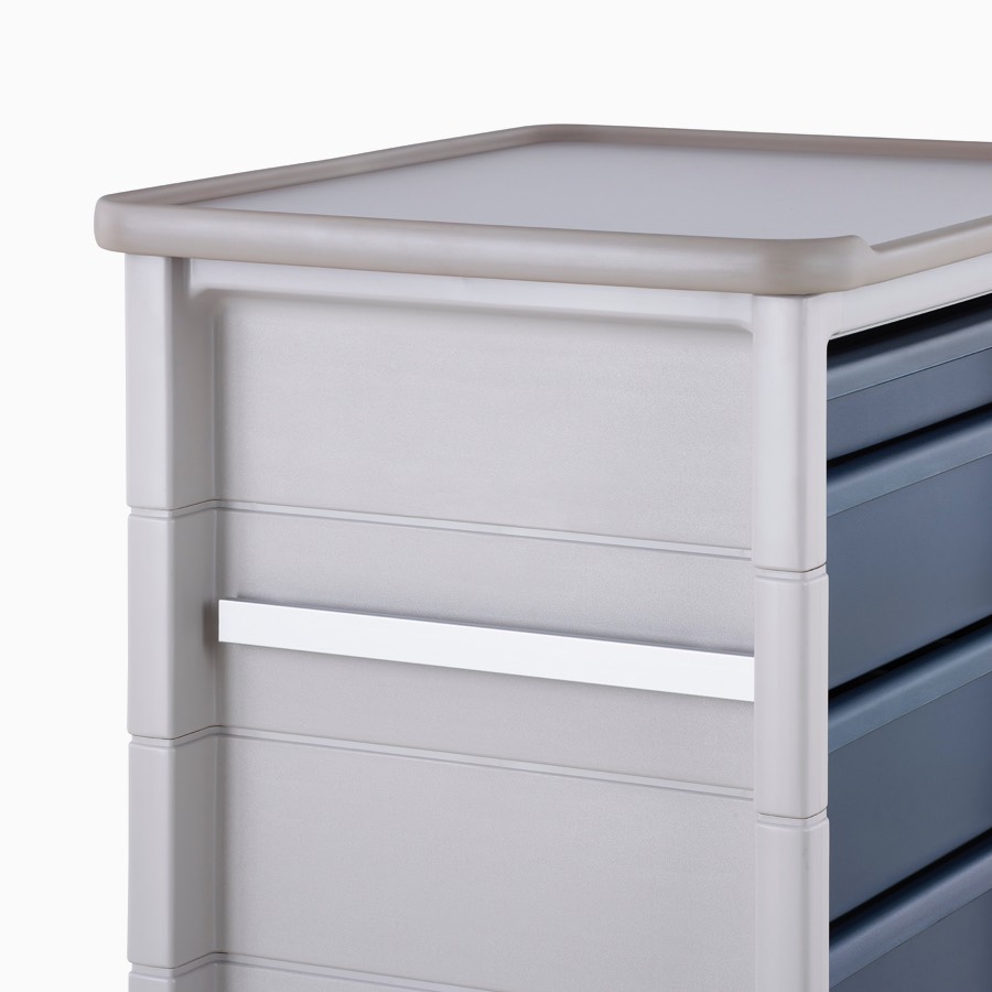 Detail of Procedure and Supply Cart in a light gray body and dark blue drawers with an accessory rail on the side of the cart.