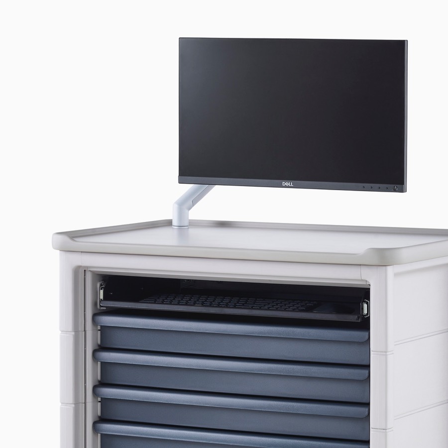 Angled view of technology cart in light gray finish with midnight blue drawers and a monitor mounted on monitor arm on top of the cart.