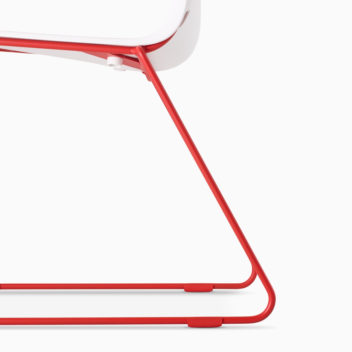 A close-up of the Atomic Red base of a Pronta Stacking chair.