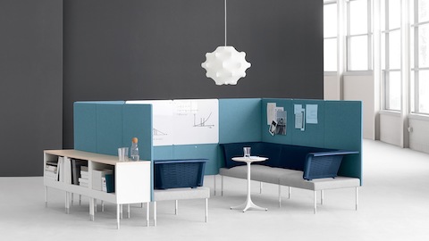 Ein teilweise geschlossener Besprechungsbereich, der aus blauen und grauen Public Office Landscape-Komponenten konfiguriert ist.