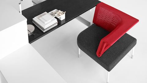 黒い表面、白いストレージ、赤い社会的な椅子で構成されたPublic Office Landscapeワークステーションのオーバーヘッドビュー。