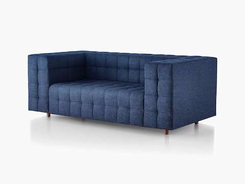 Ein Rapport Zweisitzer-Sofa mit tiefblauem Stoffbezug, im schrägen Winkel betrachtet.