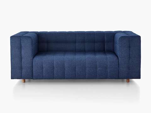 Ein Rapport Zweisitzer-Sofa mit tiefblauem Stoffbezug, im schrägen Winkel betrachtet.