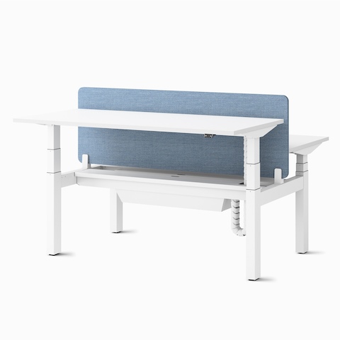 Two Ratio height-adjustable desks, positioned at seating and standing heights, back-to-back with a frameless, blue mounted privacy screen and a high-capacity tray.