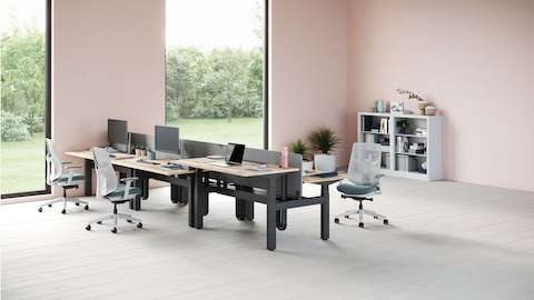 六张一组的Ratio办公桌，其中一张被设置为站立高度。背景里有一套灰色的CK2储物单元，办公桌的周围摆着三张分别为绿色和白色的Verus座椅。