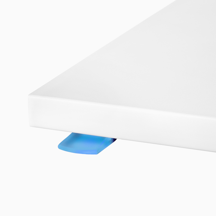 A close-up view of Renew Link standing desk system's intuitive paddle, lit blue.