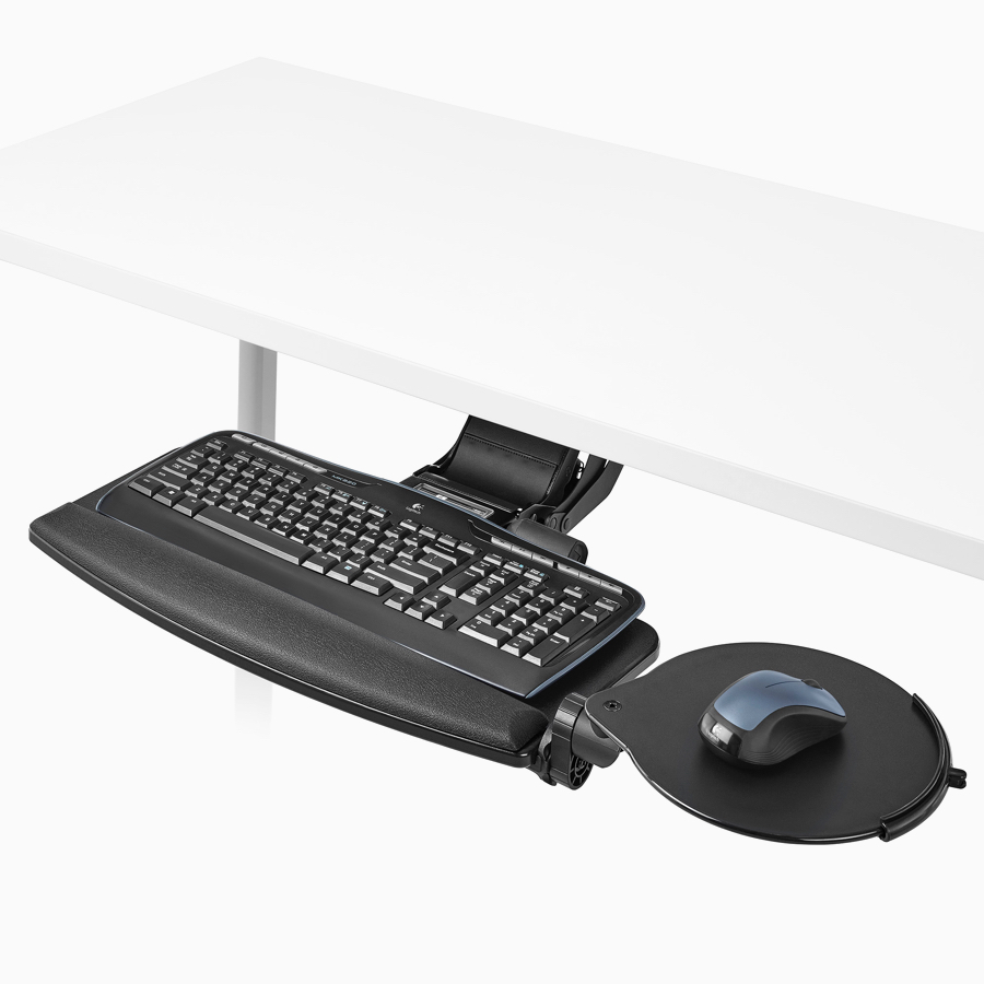 Primer plano de un soporte para teclado del sistema de escritorios elevados Renew Link con una plataforma adjunta para mouse que se extiende por debajo de una superficie de trabajo blanca.