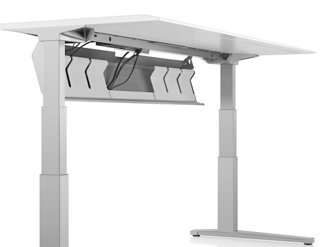 The underside of a Renew Sit-to-Stand Table, showing the cord trough in open position.