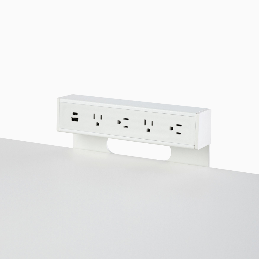Viewed at an angle, a white Logic C1000 with two USB connections and four power outlets attached to a white work surface.