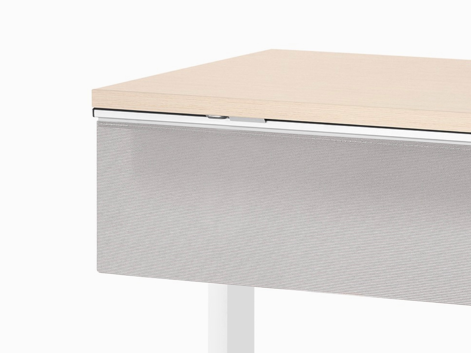 Viewed at an angle, a rectangular Everywhere Table with clear on ash woodgrain laminate work surface, white base, and a fabric modesty panel.