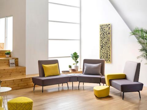 A bright collaboration area featuring Sabha Collaborative Seating elements and ottomans.