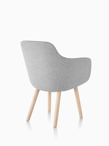 Trois-quarts arrière d'une Saiba Side Chair gris clair avec un siège baquet rembourré et des jambes en bois.
