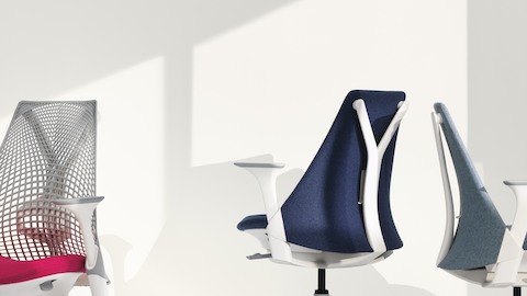 Three Sayl office chairs—white with suspension back, blue with upholstered back, and light gray with upholstered back. Three Sayl office chairs—white with suspension back, blue with upholstered back, and light gray with upholstered back.