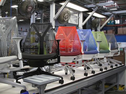 The suspension backs of gray, black, red, blue, and green Sayl chairs ready to be inspected in the manufacturing plant. The suspension backs of gray, black, red, blue, and green Sayl chairs ready to be inspected in the manufacturing plant.