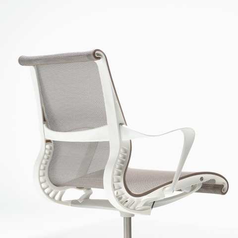 Rear-angle view of a Setu Chair with fixed arms, a studio white frame, silver alloy base and cocoa brown suspension.