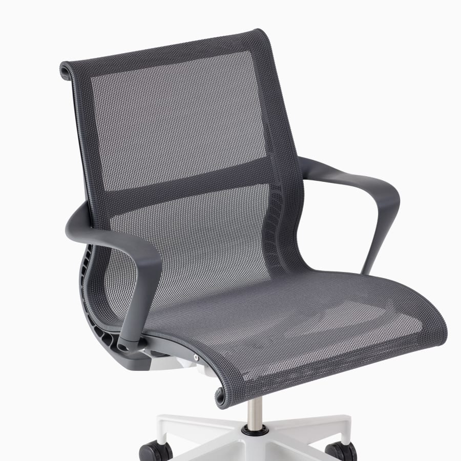 A close-up view of a Setu chair with arms in gray.