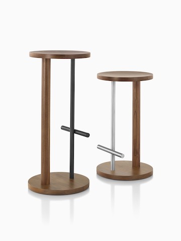 Counter-height Spot Stool in walnut with black finish and bar-height Spot Stool in walnut with satin chrome finish, viewed at angles.