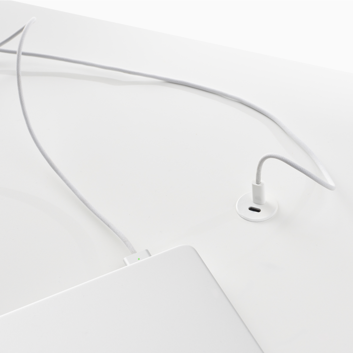 Surface-integrated dual port USB-C power solution charging a laptop shown in white.