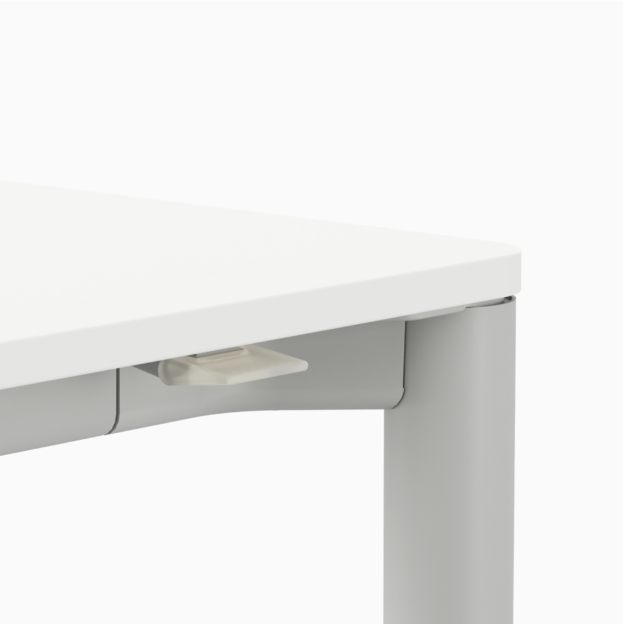 Detail of opaque intuitive paddle on a height-adjustable table with a white surface and light grey leg.