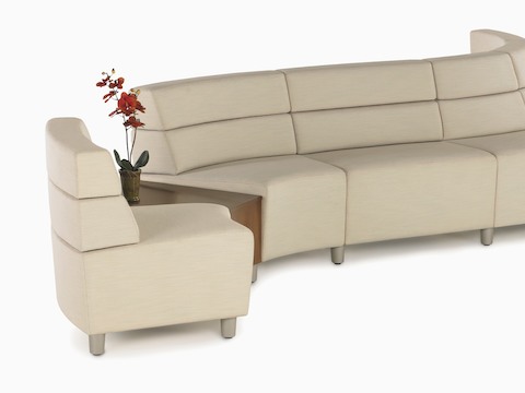 A curved configuration of beige, mid-back Steps Lounge System seating modules with an intervening surface. A curved configuration of beige, mid-back Steps Lounge System seating modules with an intervening surface.