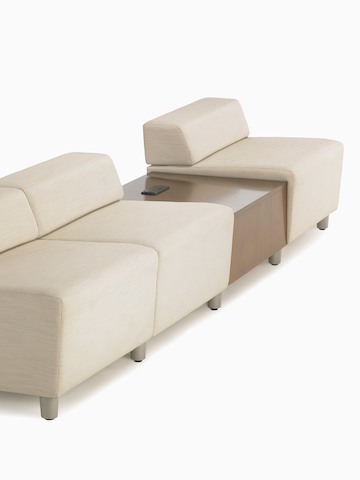 A straight configuration of three beige, low-back Steps Lounge System modules with an intervening surface offering power access. A straight configuration of three beige, low-back Steps Lounge System modules with an intervening surface offering power access.