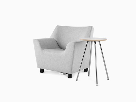 A Swoop Club Chair in light gray upholstery with attached Logic mini power source next to a Swoop Work Table with white top and chrome base. Both viewed at an angle. Power features USB-C port, USB-A port, and one A/C electrical outlet.
