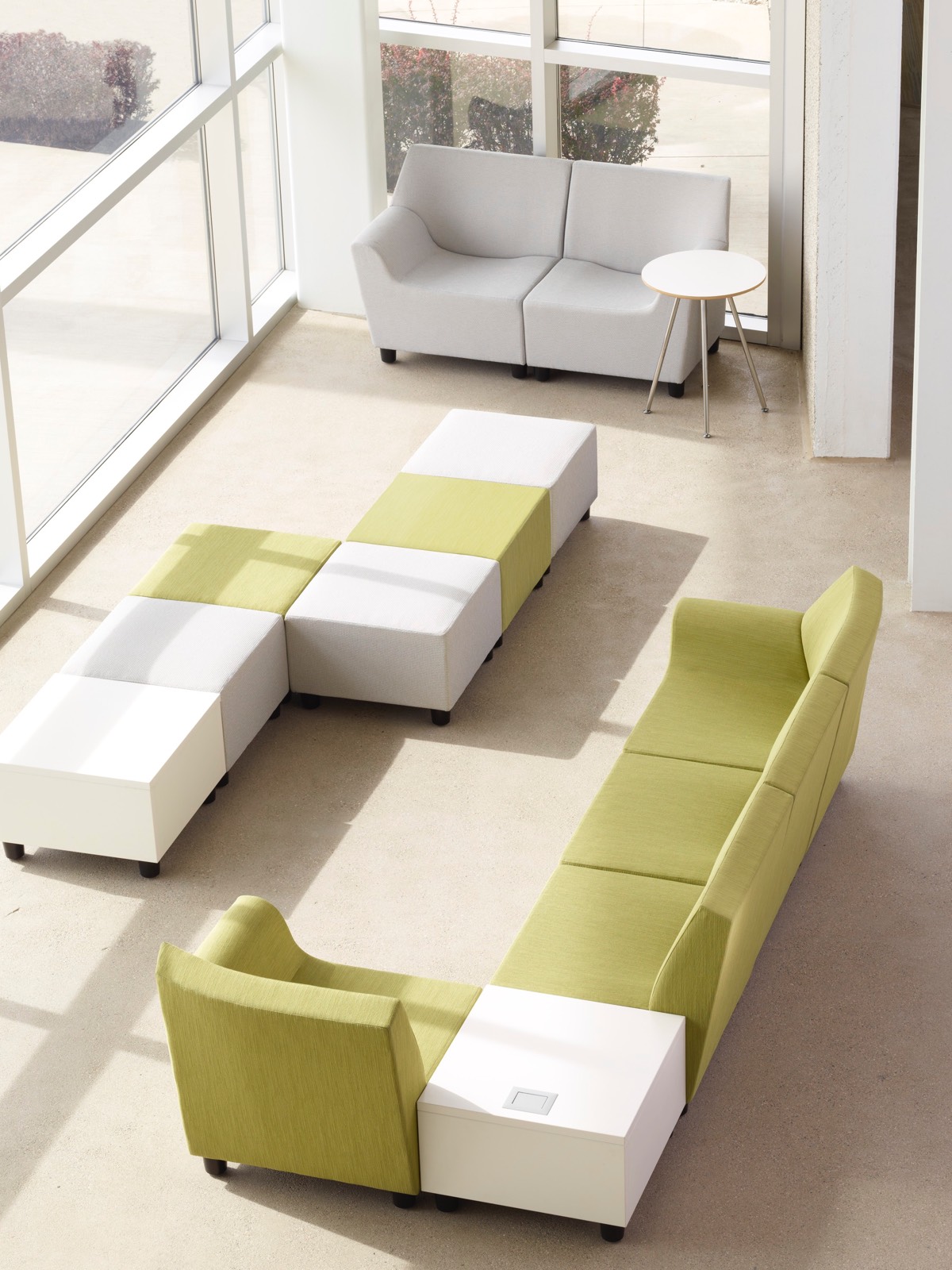 Overhead view of a casual seating area with multiple configurations of green, white, and gray Swoop modular components.