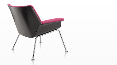 Three-quarter rear view of a Swoop lounge chair with magenta upholstery. Three-quarter rear view of a Swoop lounge chair with magenta upholstery.