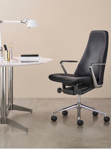Poltrona direzionale in pelle nera Taper in un moderno ufficio privato. Poltrona direzionale in pelle nera Taper in un moderno ufficio privato.